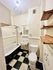 Charming bathroom with vintage clawfoot tub, checkerboard flooring, and modern light fixture.