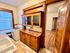 Charming kitchen with vintage wooden cabinetry, classic gas stove, and warm natural light through large windows.
