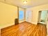 Bright and inviting bedroom with elegant wood flooring, ample natural light, and convenient closet space, leading to a cozy bathroom.