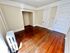 Charming room with rich hardwood floors, ample natural light, and a classic radiator, perfect for cozy living.