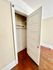 Charming closet with white door and wooden flooring, perfect for extra storage in a cozy apartment.