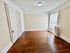 Bright and airy room with elegant wood flooring, large window, and classic white radiator.