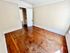 Bright room with vintage hardwood flooring and classic white trim, offering ample natural light through large windows.