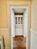 Charming kitchen nook with classic white cabinetry and rustic hardwood floors, ideal for cozy storage solutions.