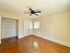 Bright, airy room featuring gleaming hardwood floors, a ceiling fan, and elegant double doors, perfect for versatile living space.