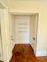 Charming hallway with rich wooden floors, two white doors, and elegant built-in shelves.
