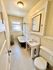 Charming vintage bathroom with classic hexagonal tile flooring, white pedestal sink, and a clawfoot bathtub.