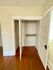Spacious walk-in closet with elegant wooden flooring and organized shelving.