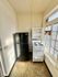 Cozy kitchen nook with modern appliances, featuring a sleek black refrigerator and a compact white stove, bathed in natural light from large windows.