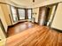 Bright, unfurnished room with elegant wood flooring, large bay windows, and a connected bathroom, perfect for personalization.