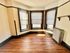 Bright corner room with elegant hardwood flooring and large windows allowing natural light.