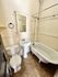 Charming bathroom with vintage clawfoot tub, pedestal sink, and classic tile flooring.