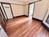 Charming room with rich wooden floors, classic white doors, and ample natural light from the adjacent kitchen area.