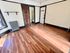 Charming apartment room with elegant wooden flooring, large window for natural light, classic radiator, and access to a private bathroom.
