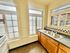 Charming kitchen with classic checkered backsplash, ample natural light from double windows, and sleek countertops.