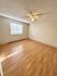 Bright, spacious bedroom featuring elegant wood flooring, a ceiling fan, and ample natural light.