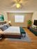 Inviting bedroom with a modern design, featuring a spacious bed, stylish furniture, and warm natural lighting.