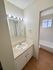 Bright and modern bathroom with elegant vanity lighting, pristine countertop, and a classic bathtub, offering a refreshing personal space.