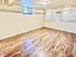 Bright, spacious room with elegant wood flooring and ample natural light, perfect for versatile use.