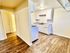 Inviting kitchen with bright cabinetry, elegant granite countertops, and rich wood flooring, perfect for culinary adventures.
