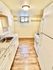 Bright and cozy kitchen featuring white cabinetry, granite countertops, and wood-style flooring.