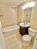 Modern bathroom with elegant tiled walls, a sleek bathtub, and stylish vanity lighting.