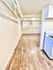 Bright apartment interior showcasing elegant wood flooring, white walls, and a cozy kitchen area.