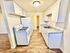 Bright and modern galley kitchen with sleek white cabinets, granite countertops, and a gas stove, offering a stylish and efficient cooking space.