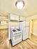 Bright kitchen with white appliances, modern cabinetry, and elegant hardwood flooring.