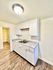 Modern kitchen with sleek white cabinetry, granite countertops, and elegant hardwood floors.