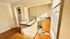 Bright and inviting kitchen area with natural light, featuring hardwood floors, tiled countertops, and modern appliances.