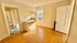 Bright and inviting apartment living space featuring a sunlit open area with hardwood floors, a cozy kitchen nook, and classic detailing.
