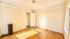 Bright room with elegant hardwood flooring, large window, and a classic radiator for a cozy atmosphere.