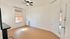 Bright and airy room featuring a ceiling fan, large window, and elegant white trim, perfect for customization.