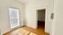 Bright room with large window and wooden floors, perfect for cozy home living.