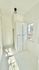 Bright and airy sunlit room with white built-in storage and large windows.