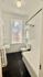 Bright bathroom with a large window, modern fixtures, and sleek black flooring, creating a clean and inviting space.