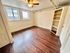 Bright and inviting room featuring rich hardwood floors, built-in shelving, and large windows for natural light.