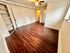 Bright room with elegant wood flooring, built-in shelves, and a ceiling fan, offering a warm and inviting atmosphere.