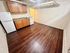 Charming kitchen with warm wooden cabinetry, sleek countertops, and modern appliances on elegant hardwood flooring.