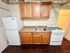 Cozy and efficient kitchen with wooden cabinetry, modern appliances, and sleek countertops, ideal for compact living.