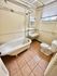 Charming bathroom with a classic clawfoot bathtub, modern sink, and natural light from a large window.