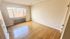 Bright and airy room with large window, polished hardwood floors, and a cozy radiator below the window, perfect for a peaceful retreat.