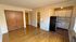 Charming apartment interior with cozy kitchen, wooden flooring, and ample storage space.