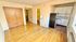 Charming apartment interior featuring elegant hardwood floors, a cozy kitchenette with white cabinetry, and a spacious closet.
