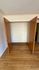 Spacious wooden closet with double doors, offering ample storage in a warm, inviting apartment setting.
