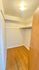 Bright walk-in closet with sleek wooden flooring and ample shelving space.