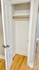 Bright and spacious closet with hardwood floors and a classic white door, ideal for organized storage.