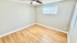 Bright and inviting room with hardwood floors, neutral walls, and a ceiling fan, ideal for a cozy bedroom or office space.