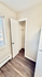 Bright and cozy apartment corner with hardwood flooring, a small closet, and natural light from the window.